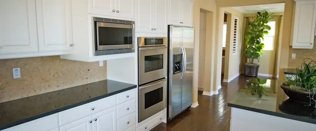 Bright kitchen with white painted cabinets and stainless steel appliances