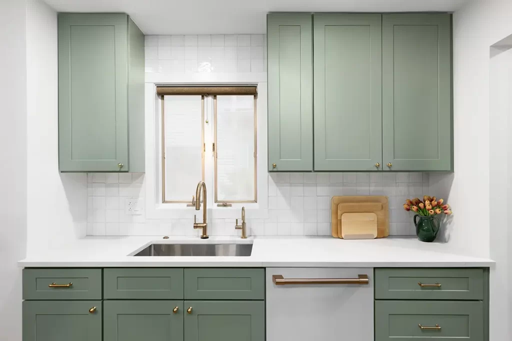 Stylish kitchen with green cabinets and gold hardware accents